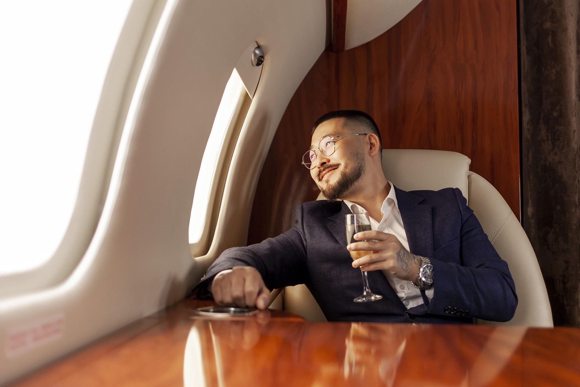 successful-asian-businessman-suit-glasses-with-glass-champagne-flies-private-luxury-jet_resize